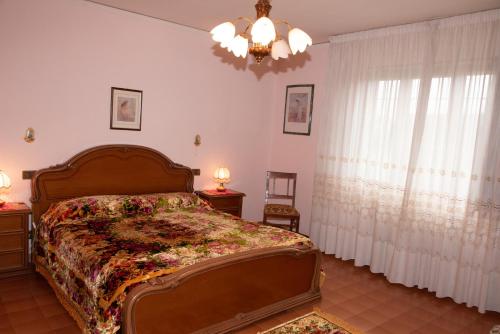 Schlafzimmer mit einem Bett und einem Kronleuchter in der Unterkunft VILLA MARIA in Altopascio