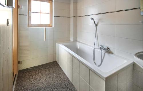 un bagno bianco con vasca e lavandino di Amazing Home In Schnberg Lachtal With Sauna a Schönberg-Lachtal