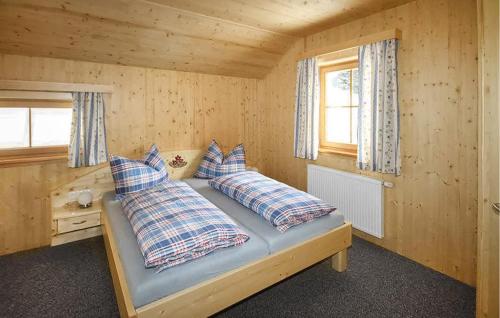 a bed in a wooden room with two pillows on it at Nice Home In Schnberg Lachtal With 5 Bedrooms, Sauna And Wifi in Lachtal
