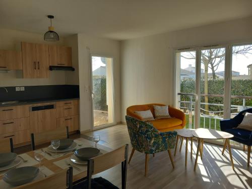 une cuisine et un salon avec une table et des chaises dans l'établissement Appartement 2 chambres proche Grande Plage, à Saint-Gilles-Croix-de-Vie