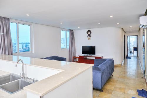 a kitchen and living room with a blue couch at A25 Hotel - 12 Ngô Sỹ Liên in Hanoi