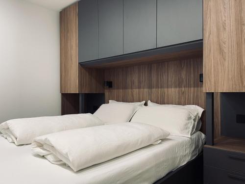 泰塞羅的住宿－Dolomiti Haus - Immerso nelle Dolomiti，一间卧室配有两张带白色枕头的床