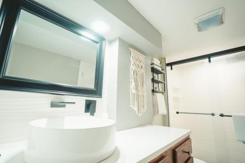 La salle de bains est pourvue d'un lavabo blanc et d'un miroir. dans l'établissement Windsor Retreat Private Basement Suite, à Denver
