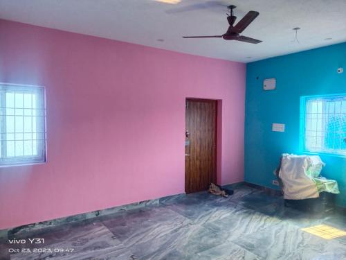 an empty room with a pink and blue wall at BHARATH VILLAS in Vāniyambādi