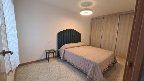 Schlafzimmer mit einem Bett und einem grünen Kopfteil in der Unterkunft Vacaciones de ensueño in Mojácar