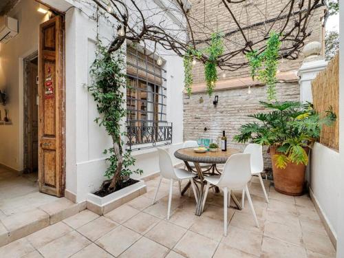 un patio con tavolo, sedie e un edificio di Cosy 4 bedroom house with private terrace a Hospitalet de Llobregat