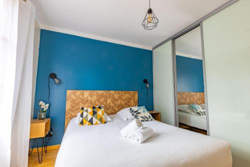 ein Schlafzimmer mit blauen Wänden und ein Bett mit Handtüchern in der Unterkunft L'atelier des rêves, Maison avec Piscine privée in Meusnes