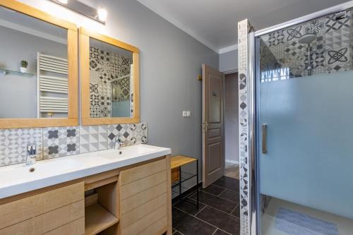ein Bad mit einem Waschbecken und einer Dusche in der Unterkunft L'atelier des rêves, Maison avec Piscine privée in Meusnes
