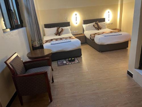 ein Hotelzimmer mit 2 Betten und einem Stuhl in der Unterkunft Hotel 21 in Aksum