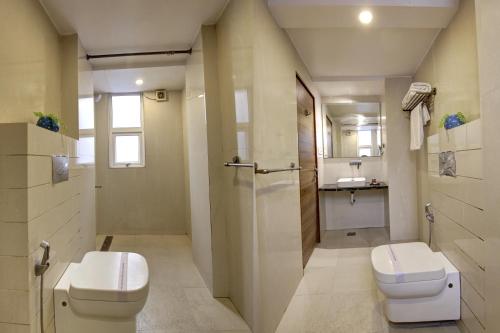 a bathroom with a toilet and a sink at The Shanti Plaza - Traveler's choice awarded 2025 in New Delhi