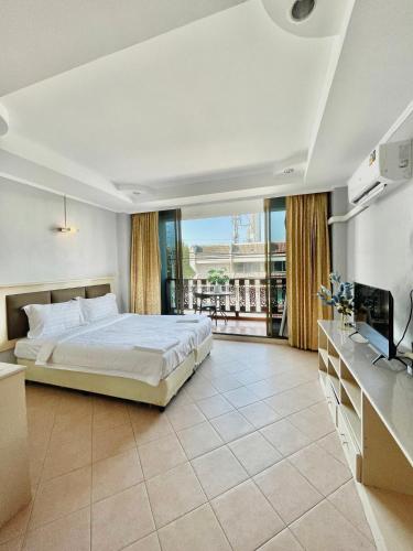 a bedroom with a large bed and a balcony at Nona Pattaya Hotel in Jomtien Beach