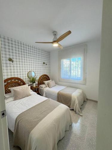 a bedroom with two beds and a window at Nuevo Torrox Deluxe Beach & Piscina in Torrox