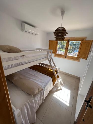 阿爾穆涅卡爾的住宿－Cortijo Cantalobos，一间卧室配有双层床和窗户。