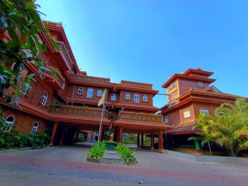 a large wooden building with a clock tower at Krishna Beach Resort in Kannur