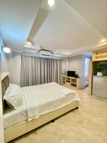a bedroom with a large bed in a room at Nona Pattaya Hotel in Jomtien Beach