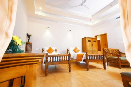 a room with two wooden benches and a bed at Krishna Beach Resort in Kannur