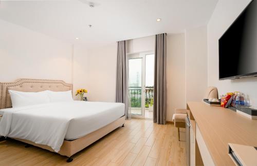 a bedroom with a white bed and a television at RHM Luxury Hotel And Suite in Danang