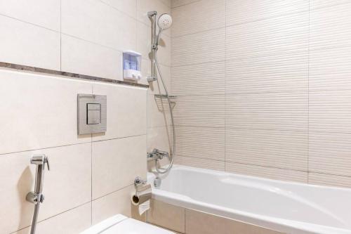 y baño con ducha y bañera. en Landing Lane Family Suites, Studio Near DXB Airport, en Dubái