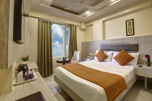 una camera d'albergo con letto e finestra di Hotel Shanti Plaza-by Haveliya Hotels a Nuova Delhi