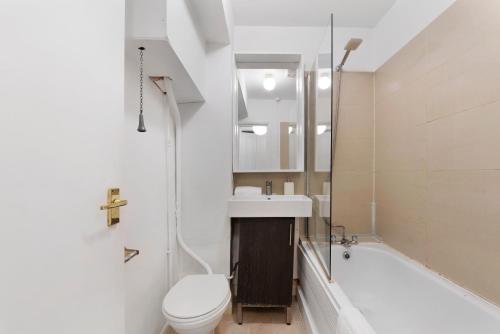 a bathroom with a toilet and a sink and a tub at Flat 1 - 2 Bedrooms and Private Terrace in London