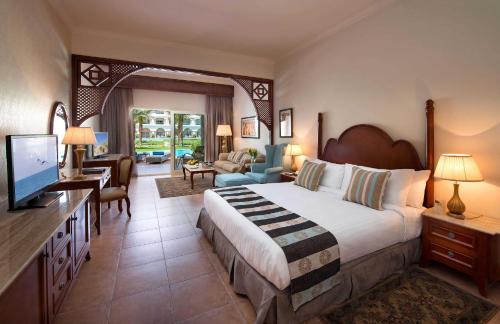 a bedroom with a large bed and a living room at Baron Palace Sahl Hasheesh in Hurghada