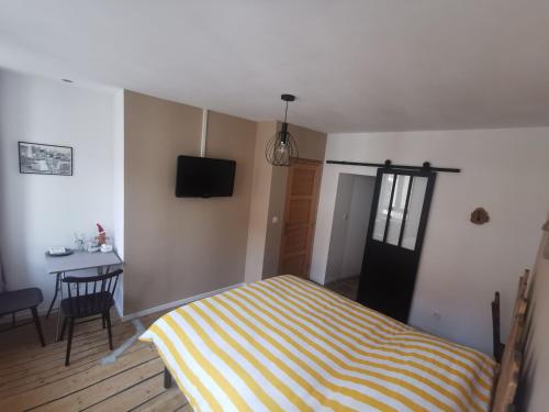 Schlafzimmer mit einem Bett, einem Tisch und einem TV in der Unterkunft La chambre de pousse in Boulogne-sur-Mer