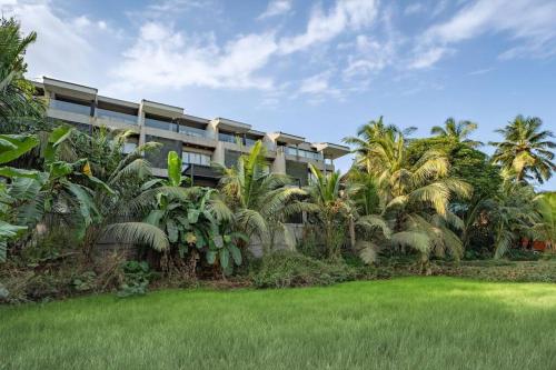um edifício com palmeiras em frente a um quintal em August Villas, Saligao -3BHK's w Private Plunge Pool em Saligao