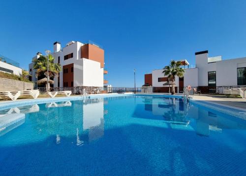 una piscina con acqua blu di fronte a un edificio di Beautiful Middel Views Apartment with pool and gym a Málaga
