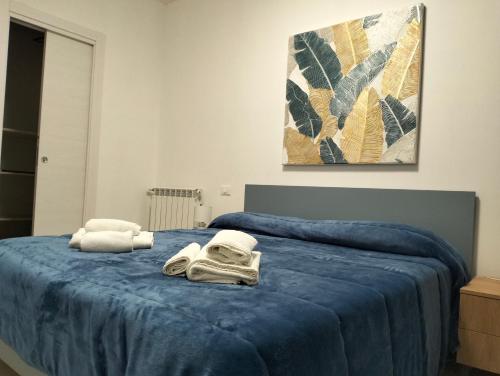 sypialnia z niebieskim łóżkiem i ręcznikami na nim w obiekcie Chalaroste home w mieście Terrasini