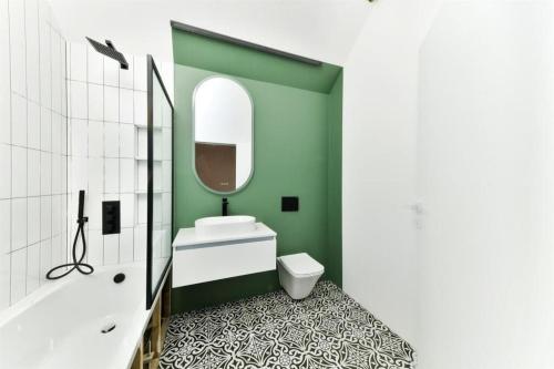 ein Badezimmer mit einem Waschbecken, einem WC und einem Spiegel in der Unterkunft Big 4 Bed House, Close to Gatwick (15 mins) in Redhill