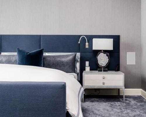 ein Schlafzimmer mit einem blauen und weißen Bett und einer Lampe in der Unterkunft Big 4 Bed House, Close to Gatwick (15 mins) in Redhill
