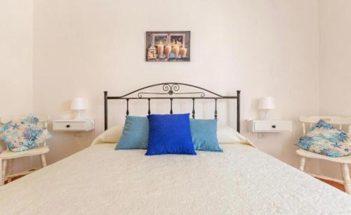 a bedroom with a large bed with blue pillows at La Casetta Al Mar in Porto Cesareo