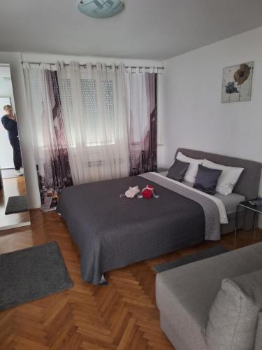 una camera con un grande letto e un divano di Apartman Sweet penthouse self check-in a Karlovac
