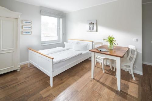 a bedroom with a bed and a desk and a table at Haus Delft Agadir in Juist