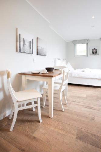 a dining room with a table and chairs and a bed at Haus Delft Jakea in Juist