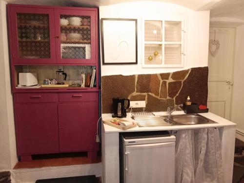 a kitchen with red cabinets and a sink at Studio in Altstadthaus in Sankt Veit an der Glan