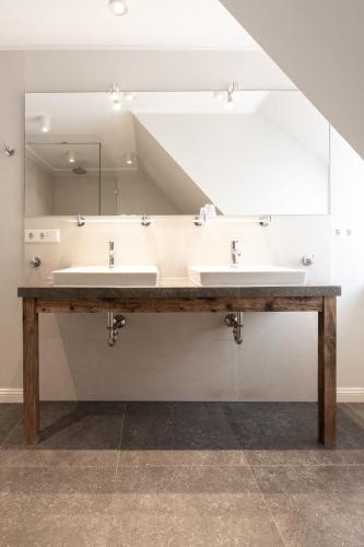 a bathroom with two sinks and a large mirror at Haus Delft Jaap Jacoba in Juist