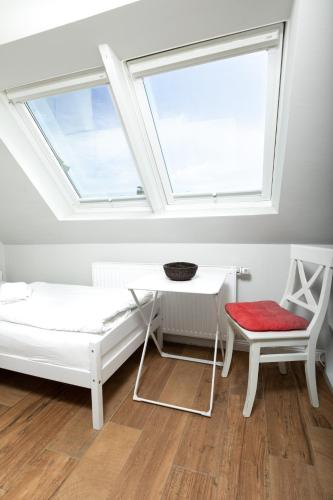 a room with a bed and a desk and a window at Haus Delft Ilmenau in Juist