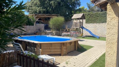 une piscine dans une cour avec un toboggan et une aire de jeux dans l'établissement VILLA très bien équipée pour les vacances, à Boisset-et-Gaujac