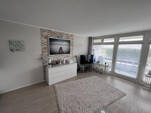 a living room with a flat screen tv and a tv stand at Singlefewo Seemöwe für 1 Person in Staberdorf