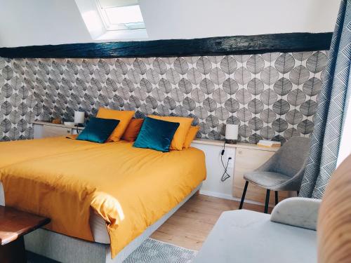 1 dormitorio con 1 cama con almohadas de color naranja y azul en La Maison Flore ! Confort et Nature, en Flexbourg