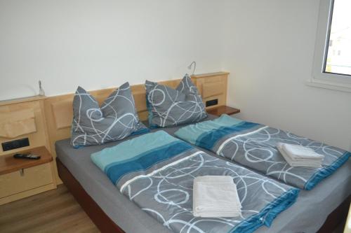 a bed with pillows on it in a room at Apartment Ausblick in Tamsweg