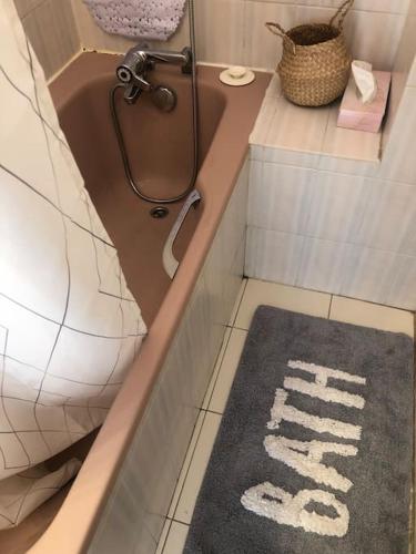 een badkamer met een bad en een tapijt op de vloer bij Beau T3 face Rouet plage avec garage in Carry-le-Rouet