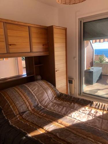 een slaapkamer met een bed en een groot raam bij Beau T3 face Rouet plage avec garage in Carry-le-Rouet