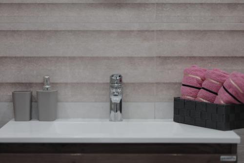 a bathroom sink with pink towels and a faucet at Apartmani Vinea Lana in Vrbovec