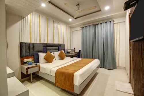 a bedroom with a bed and a television in it at The Shanti Plaza - Traveler's choice awarded 2025 in New Delhi