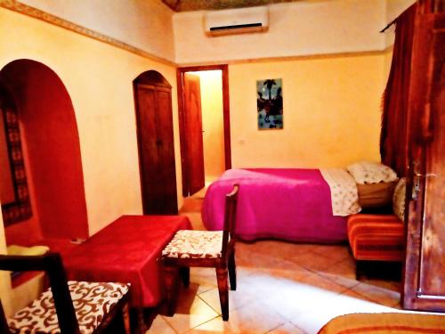 Un dormitorio con una cama, un sofá y una silla. en Riad Tifor, en Marrakech