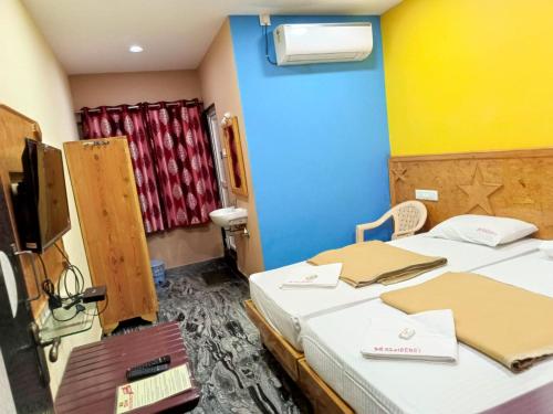 a hospital room with two beds and a tv at SM Residency in Coimbatore