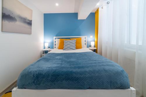 een slaapkamer met een groot bed met een blauwe muur bij Déja Blue Old City Center studio. in Sofia
