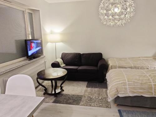 a living room with a couch and a bed at Studio Porin Oksi, home away home in Pori city center, free parking in Pori